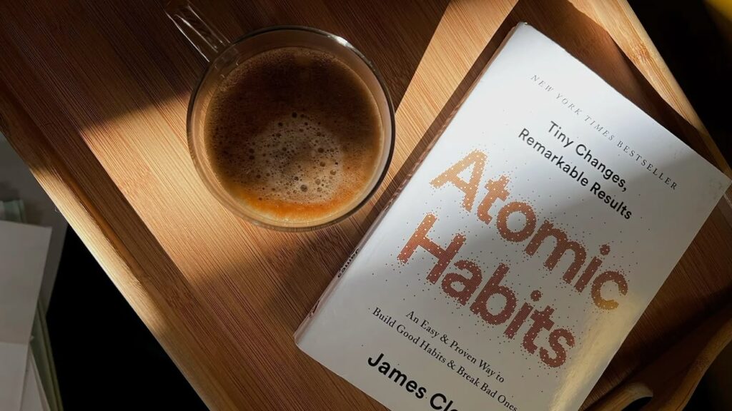 Book and coffee on wooden table.